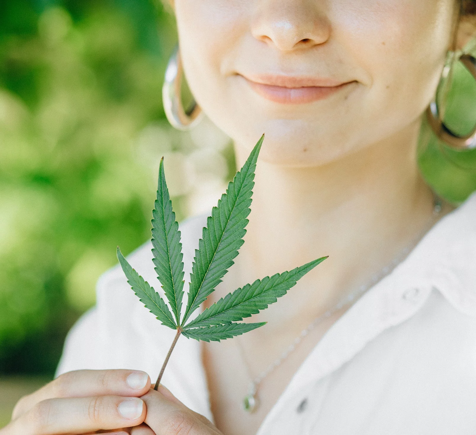 woman holding cannabis leaf