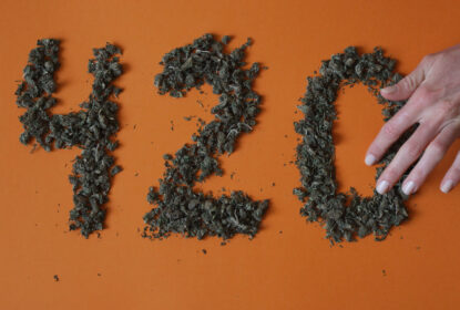 hand make a sign 420 from a hemp buds on red background