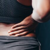 woman holding lower back pain